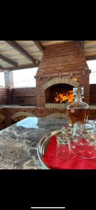 a bottle of whiskey on a tray next to a brick oven at Casa Cu Lavandă in Valea Drăganului