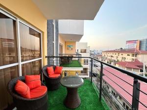 a balcony with two chairs and a table on a building at NEW! 2BDR Maisonette with PS5 and balcony in Lekki phase one in Lekki