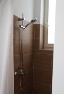 La salle de bains est pourvue d'une douche et de carrelage brun. dans l'établissement Casa Nostra - Helle Wohnung - direkt am Augarten, à Vienne