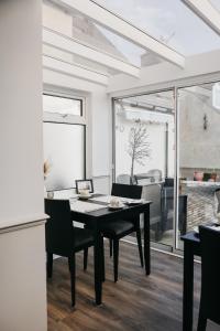 a dining room with a black table and chairs at Pitfaranne Guest House in Inverness