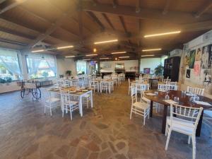 a dining room with tables and white chairs at CHouse Golf MarediRoma in Ardea +27 photos