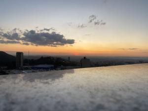 a view of the sunset from the top of a building at Cobertura Espetacular no Belvedere com Jacuzzi in Belo Horizonte