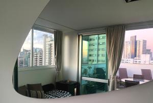 a room with a window with a view of a city at Cobertura Espetacular no Belvedere com Jacuzzi in Belo Horizonte