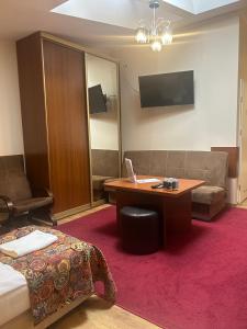 a hotel room with a bed and a desk with a laptop at Hotel Ajax in Janki
