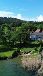 a house on a hill next to a river at Seevilla Nina in Maria Wörth