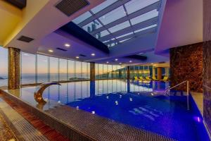 a large swimming pool in a building with a large window at Budva Central Escape Apartment in Budva