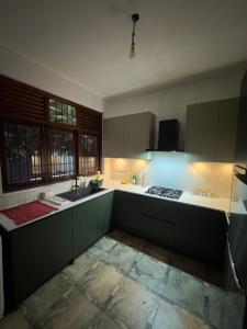 a kitchen with green cabinets and a sink at Perera Tree Villa in Ja-Ela