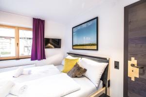 a bedroom with a bed and a tv on the wall at Blackriver Lodge Saalbach in Saalbach-Hinterglemm