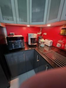 a kitchen with red walls and a counter top at Home Valot Bed and Breakfast in Lan Saka