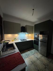a kitchen with gray cabinets and a stove top oven at Perera Tree Villa in Ja-Ela