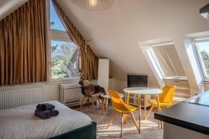 a bedroom with a bed and a table and chairs at Les Cognassiers - Studio Cosy & Equipé - Parking Gratuit - Professionnels & Familles in Illkirch-Graffenstaden
