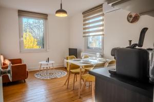a kitchen and living room with a table and chairs at Les Cognassiers - Studio Cosy & Equipé - Parking Gratuit - Professionnels & Familles in Illkirch-Graffenstaden