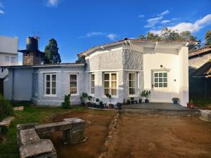 a white house with a dirt yard at Milhaven Crest in Kodaikānāl