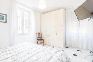 a white bedroom with a bed and a chair at Preia de ma in Levanto