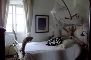 a bedroom with a large bed with a wooden headboard at Chambre des amoureux, la Casamatta in Centuri +7 photos