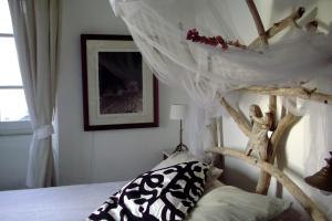 a bedroom with a bed with a wooden canopy at Chambre des amoureux, la Casamatta in Centuri