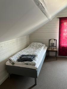 a bed in a room with a red window at Gästhus i Västanbyn, Sandviken in Sandviken
