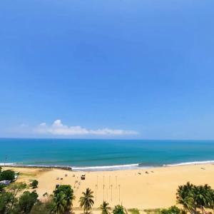a view of a beach with palm trees and the ocean at Negombo Sea waves in Negombo +1 photo
