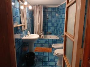 ein blau gefliestes Badezimmer mit Waschbecken und Toilette in der Unterkunft Al Rol in Manzano + 106 Fotos