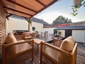 a patio with chairs and tables on a deck at Maisons Sauvages - Piscine & Jacuzzi - Proche Zoo de Beauval & Châteaux in Romorantin