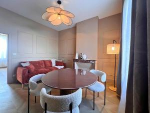 a living room with a table and chairs and a couch at Maisons Sauvages - Piscine & Jacuzzi - Proche Zoo de Beauval & Châteaux in Romorantin