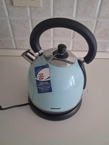 a blue electric tea kettle sitting on a counter at L'edera in Tuscania