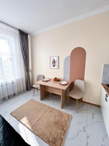 a living room with a wooden table and chairs at Bekarys Twins in Astana