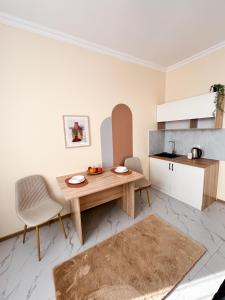 a small kitchen with a wooden table and chairs at Bekarys Twins in Astana