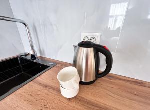 a tea kettle on a counter next to a sink at Bekarys Twins in Astana