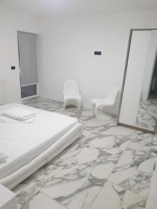 a white room with a bed and a mirror at Casa Party in Fîntînele