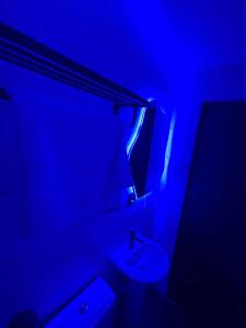 a bathroom with a white sink and a blue light at NEW! 2BDR Maisonette with PS5 and balcony in Lekki phase one in Lekki +28 photos