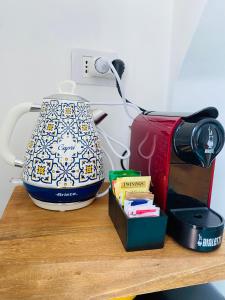 a tea pot sitting on a wooden shelf with books at Antico Borgo in Minori