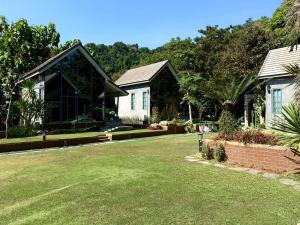 a house with a lawn in front of it at El Vaso Resort in Chanthaburi