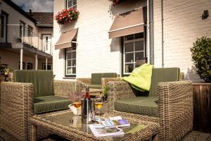 a patio with wicker chairs and a table with wine glasses at Aparthotel Ons Epen in Epen +65 photos