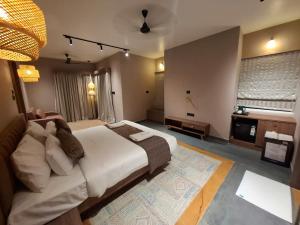a large bedroom with a large bed and a television at Kayo Resort Pench in Seonī