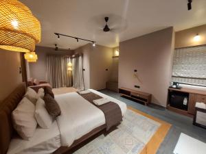 a bedroom with a large bed and a television at Kayo Resort Pench in Seonī