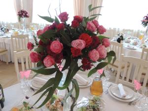 a vase filled with red roses on a table at Biдень in Lviv