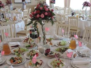 a table with plates of food and flowers on it at Biдень in Lviv