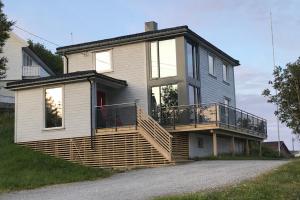 a house with a large deck on the side of it at Villa valen, Reine in Moskenes
