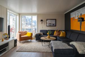 a living room with a blue couch and a chair at Villa valen, Reine in Moskenes