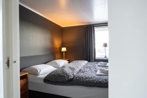 a bedroom with a bed with white pillows and a window at Villa valen, Reine in Moskenes