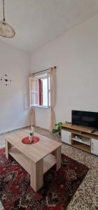 a living room with a coffee table and a television at Niki's Cozy Home in Kalymnos +3 photos