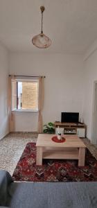 a living room with a table with a laptop on it at Niki's Cozy Home in Kalymnos