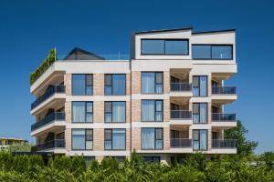 an apartment building with balconies and a blue sky at AthmosphereVillaEma Apartments in Kranevo