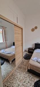 a bedroom with two beds and a large mirror at Niki's Cozy Home in Kalymnos