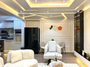 a living room with two white chairs and a kitchen at NEW! 2BDR Maisonette with PS5 and balcony in Lekki phase one in Lekki