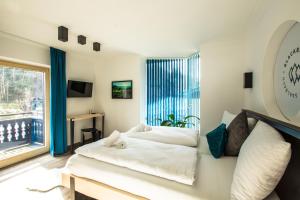 a bedroom with two beds and a large window at Blackriver Lodge Saalbach in Saalbach-Hinterglemm