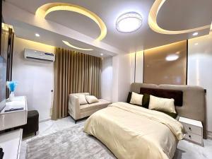 a bedroom with a bed and a chair in it at NEW! 2BDR Maisonette with PS5 and balcony in Lekki phase one in Lekki