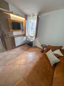 a living room with a couch and a television at Cozy 18th century house in San Gimignano