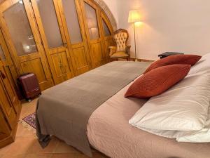 a bedroom with a large bed with red pillows at Cozy 18th century house in San Gimignano